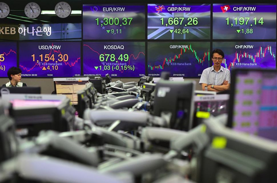 Currency dealers monitor exchange rates in front of screens showing exchange rates for Korean won against the Pound and the Euro (C top) in a trading room at the KEB Hana Bank in Seoul on June 24, 2016. South Korean shares turned lower in late morning on June 24, as the results of the British referendum remain murky. 
