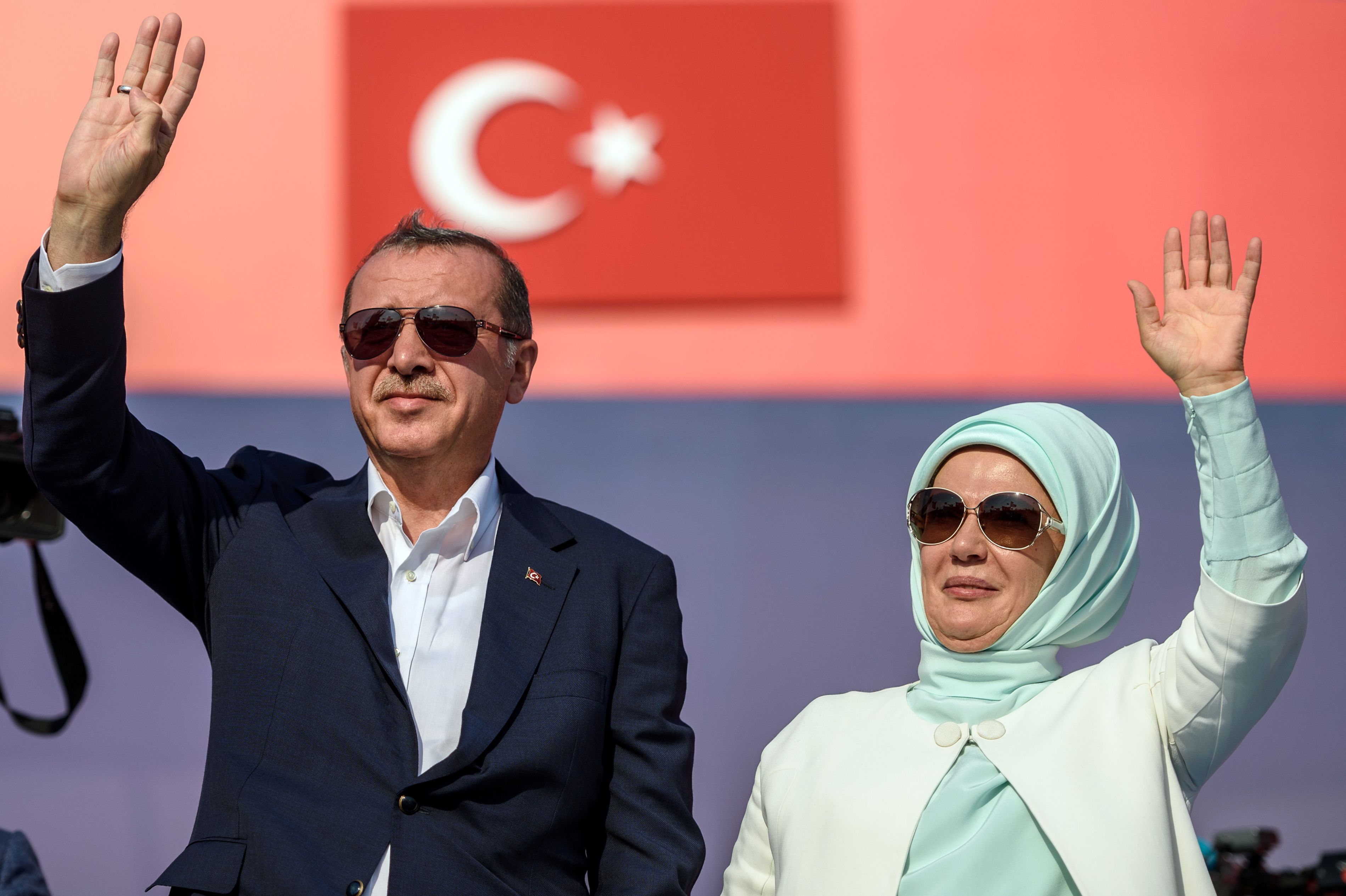 Turkish President Recep Tayyip Erdogan (L) and First Lady Emine Erdogan (R) wave at supporters on August 7, 2016 in Istanbul during a rally against failed military coup on July 15.