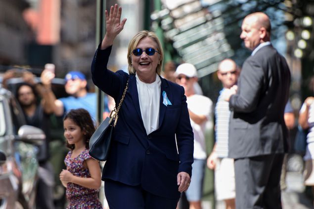 TOPSHOT - US Democratic presidential nominee Hillary Clinton waves to the press as she leaves her daughter's apartment building after resting on September 11, 2016, in New York. Clinton departed from a remembrance ceremony on the 15th anniversary of the 9/11 attacks after feeling "overheated," but was later doing "much better," her campaign said. / AFP / Brendan Smialowski 