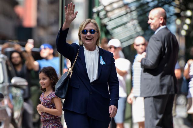 TOPSHOT - US Democratic presidential nominee Hillary Clinton waves to the press as she leaves her daughter's apartment building after resting on September 11, 2016, in New York. Clinton departed from a remembrance ceremony on the 15th anniversary of the 9/11 attacks after feeling "overheated," but was later doing "much better," her campaign said. / AFP / Brendan Smialowski