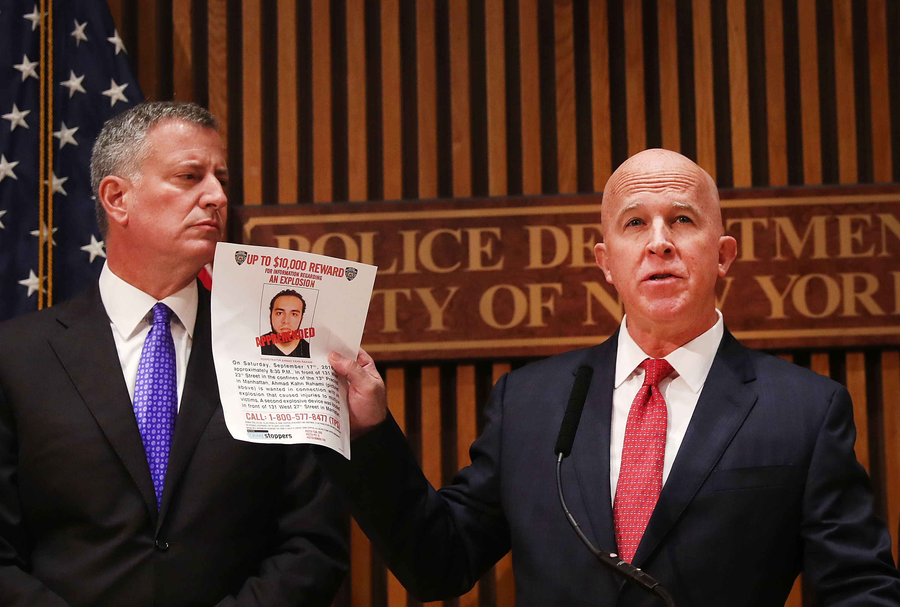 New York City police commissioner James O'Neill stands with Mayor Bill de Blasio as he holds up a picture of Ahmad Khan Rahami, the man believed to be responsible for the explosion in Manhattan on Saturday night and an earlier bombing in New Jersey, at a news conference at New York City on September 19, 2016 in New York City. Rahami was taken into custody on Monday afternoon.