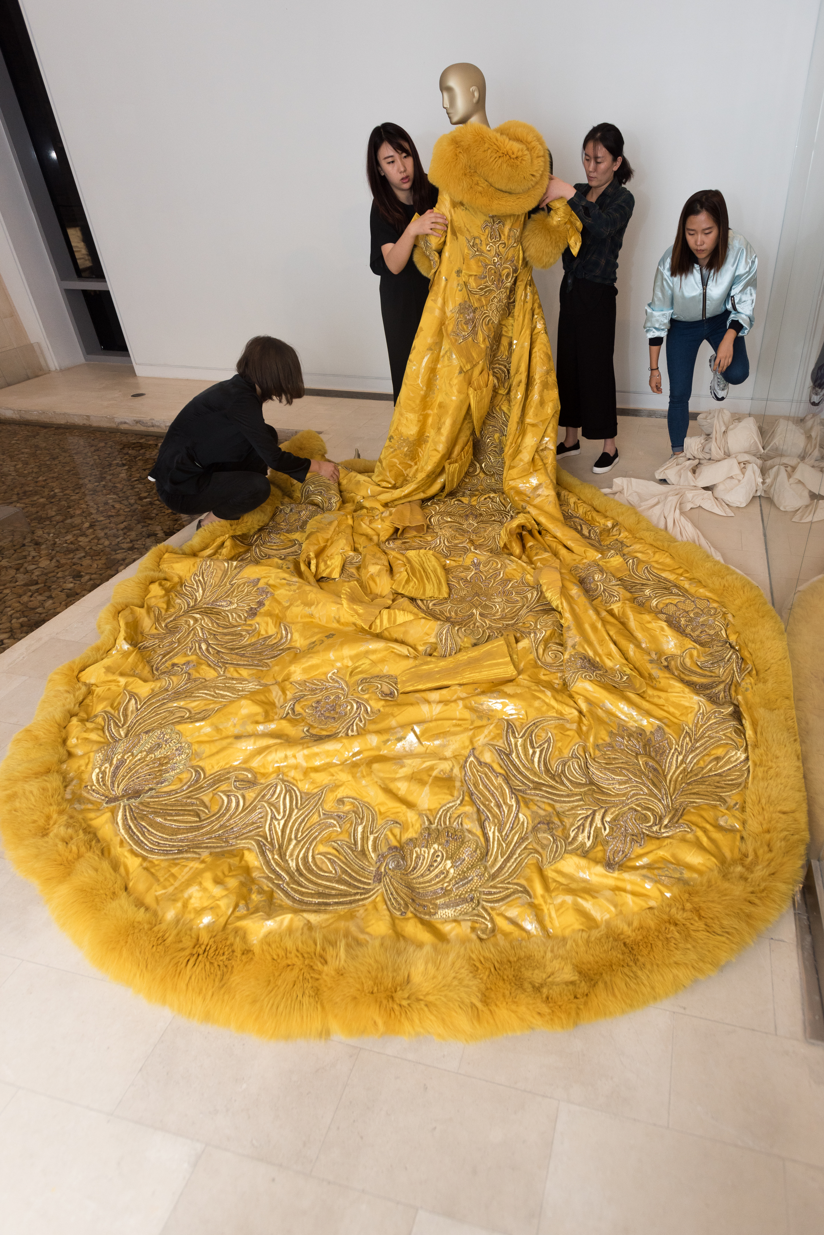 Volunteers at the China Institute dress a mannequin with the dress worn by Rihanna to the Met Gala.