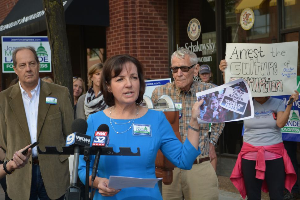 This is Joan McCarthy Lasonde at her press conference in front of Jan’s district office in downtown Evanston. Lasonde demanded that Schakowsky resign based on her alleged complicity in what Lasonde referred to as “orchestrated political violence.” The photo she’s holding up is Jan at a rally outside the Governor’s Dinner in downtown Chicago holding up the “Gang of Hate” sign printed by her husband’s subcontractors at Americans United for Change.