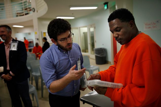 APDS instructor Dylan Alban introduces an APDS tablet to an inmate in the San Francisco County Jail.