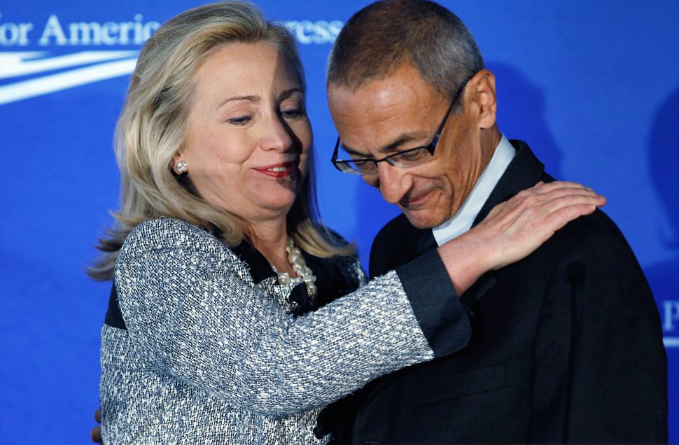 U.S. Secretary of State Hillary Clinton (L) embraces Center for American Progress President and CEO John Podesta before addressing the centers' "American Idea: A More Perfect Union" conference at the Decatur House October 12, 2011 in Washington, DC. 