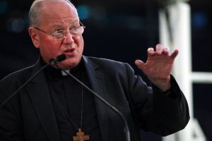 Cardinal Timothy Dolan speaks while unveiling the chair Pope Francis will use during Mass at Madison Square Garden last year.