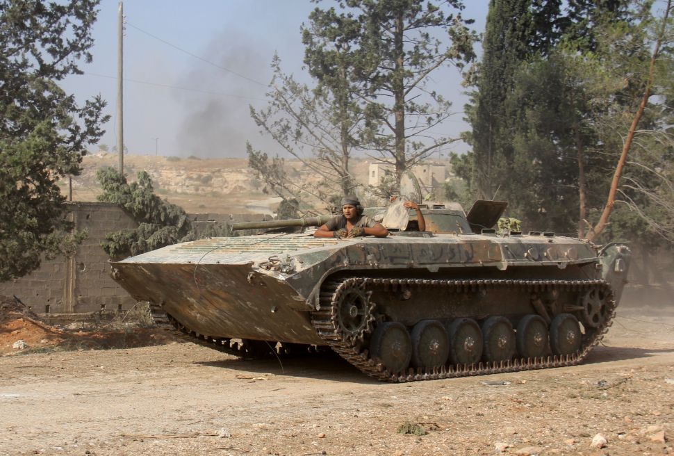 Fighters from the former Al-Nusra Front -- renamed Fateh al-Sham Front after breaking from Al-Qaeda -- drive a tank as they seized key positions south of Aleppo on August 6, 2016
