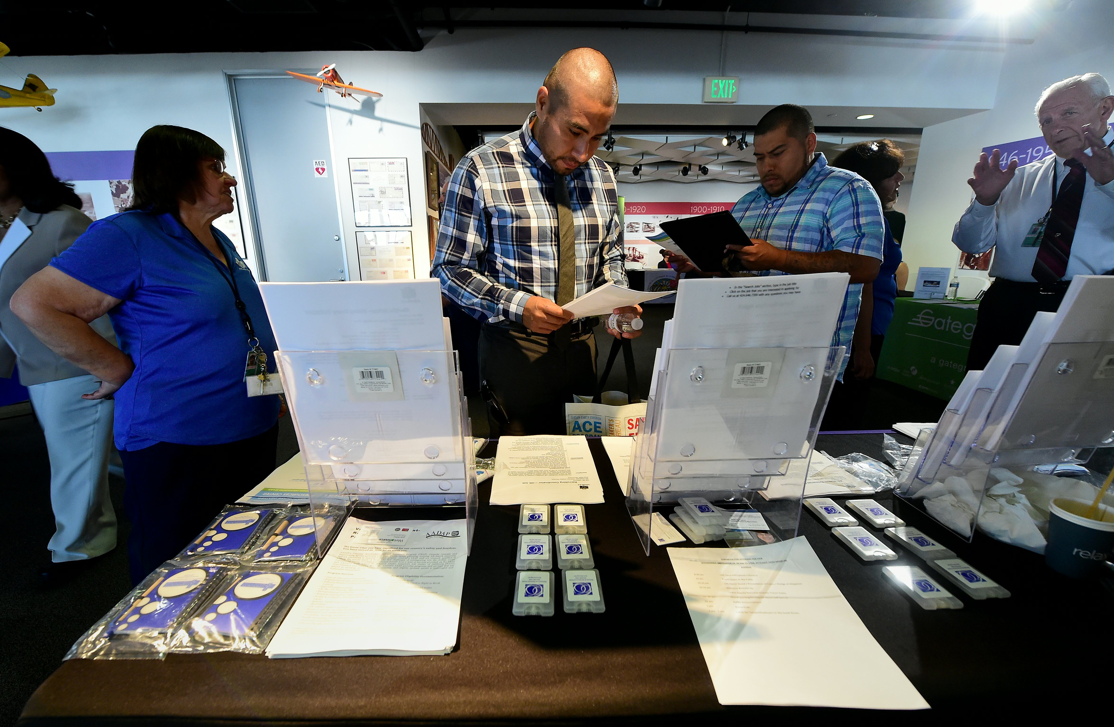Albert Dorado (C), who served in the Marines, looks over forms while attending the first Los Angeles International Airport (LAX) Job Fair for Veterans in Los Angeles, California on September 14, 2016.