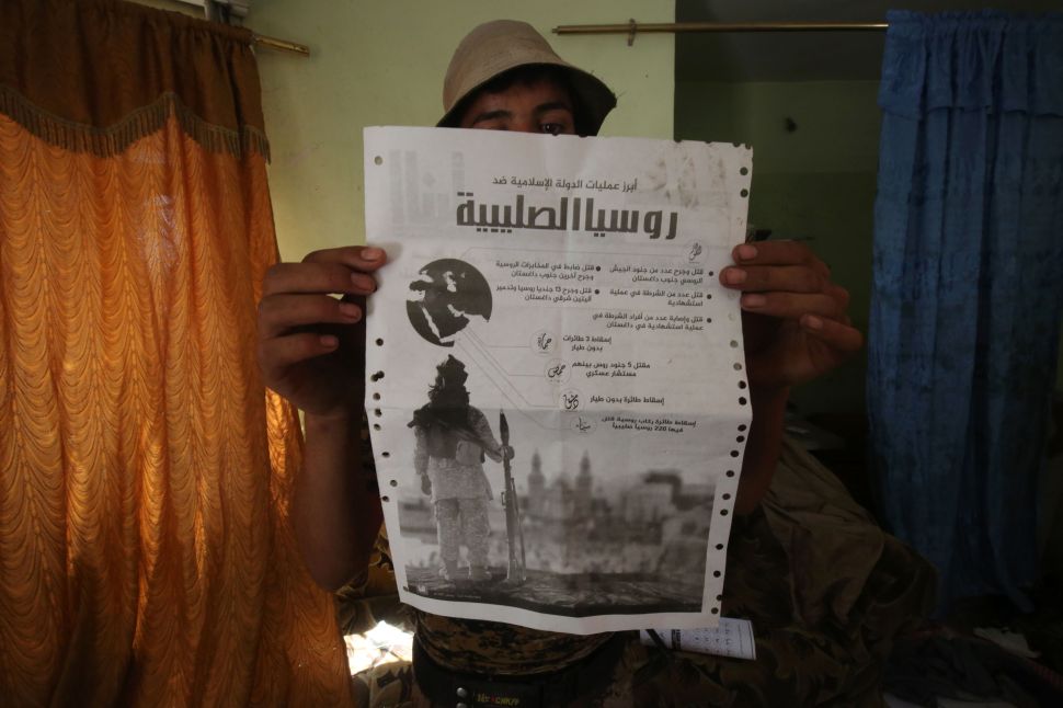 A Sunni fighter from the Popular Mobilisation Units supporting the government forces holds up a document he found in a building in the town of Sharqat around 80 kilometres (50 miles) south of the city of Mosul, giving details on IS's campaign against Russia the day after they recaptured the northern town from the Islamic State (IS) group on September 23, 2016, Security forces began the operation on September 20, 2016 to oust the Islamic State group from Sharqat, a town near supply lines needed for the battle to retake second city Mosul from the jihadists.