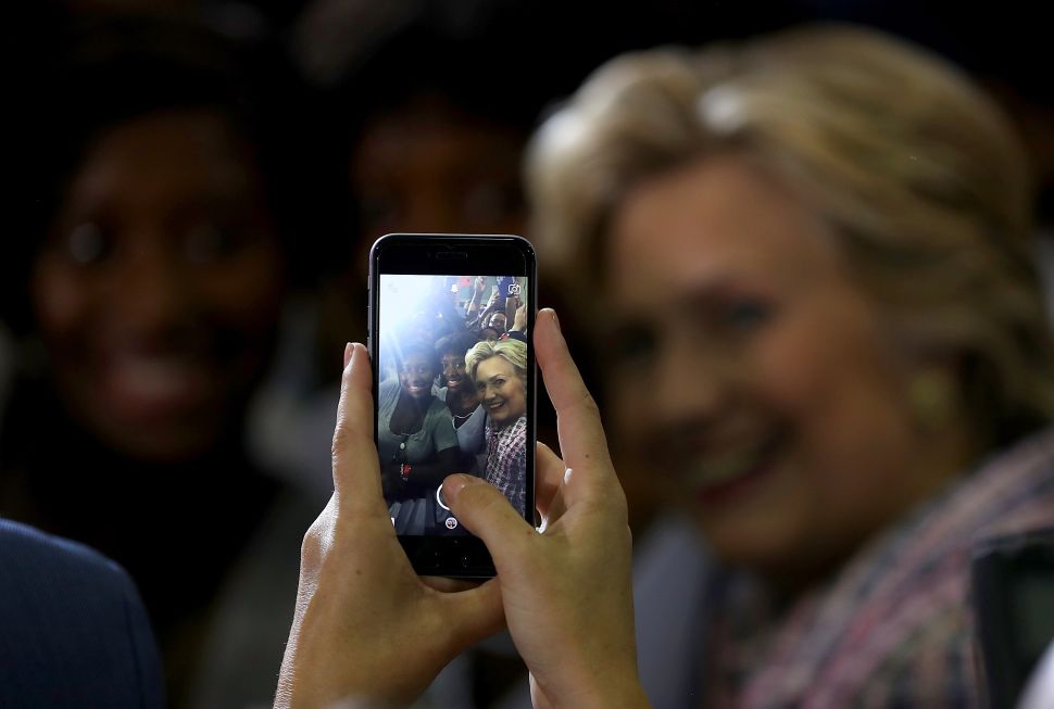 Democratic presidential nominee former Secretary of State Hillary Clinton takes a selfie with a supporter during a campaign rally at Coral Springs Gymnasium on September 30, 2016 in Coral Springs, Florida. Hillary Clinton is campaigning in Florida.