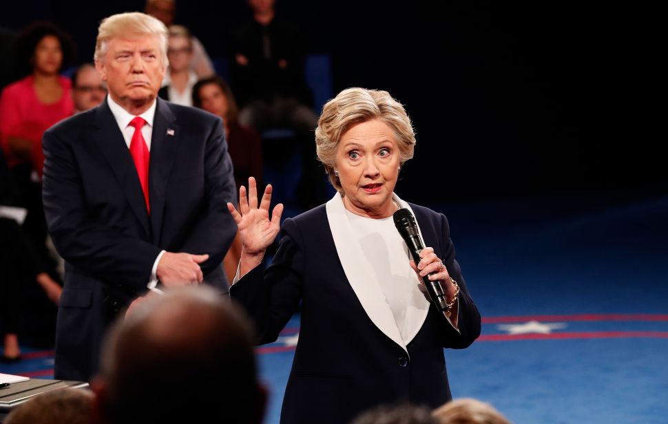 ST LOUIS, MO - OCTOBER 09: Democratic presidential nominee former Secretary of State Hillary Clinton (R) speaks as Republican presidential nominee Donald Trump listens during the town hall debate at Washington University on October 9, 2016 in St Louis, Missouri. This is the second of three presidential debates scheduled prior to the November 8th election.