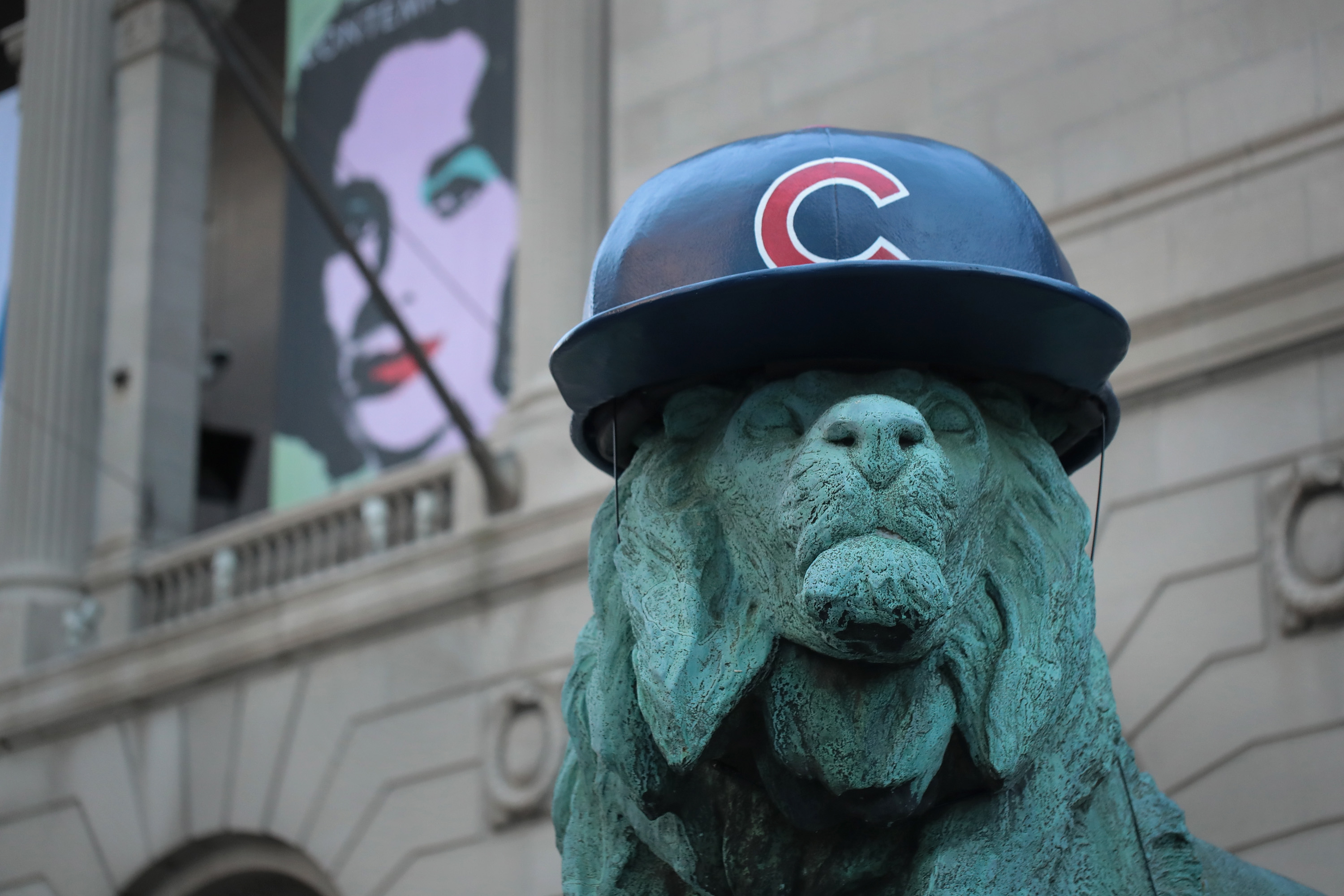 CHICAGO, IL - OCTOBER 24: A lion sculpture outside the Art Institute of Chicago wears a batting helmet to help the city celebrate the Chicago Cubs making it into the World Series on October 24, 2016 in Chicago, Illinois. The Cubs will face off against the Cleveland Indians in the World Series beginning tomorrow. This will be the Cubs first trip to the Series since 1945. The Indians last trip to the Series was 1948.