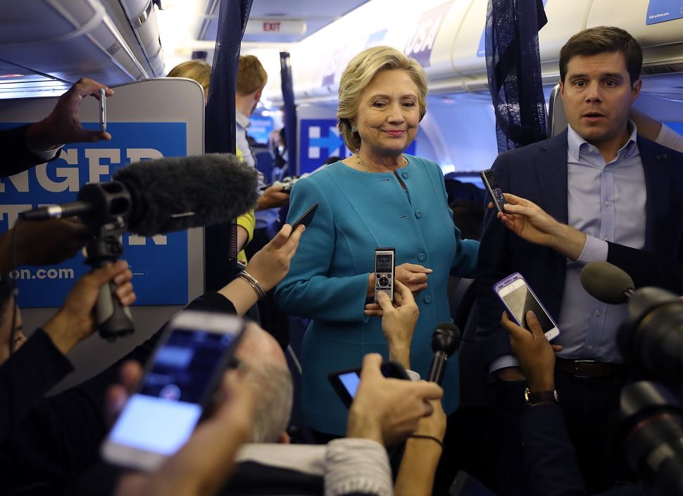 Democratic presidential nominee former Secretary of State Hillary Clinton speaks to reporters on her campaign plane while traveling from Tampa, Florida to New York on October 26, 2016.