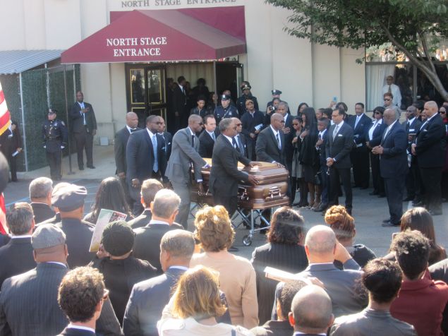 The late Brooklyn District Attorney Ken Thompson's wife, children and attendees look on as his casket is taken out of the center.
