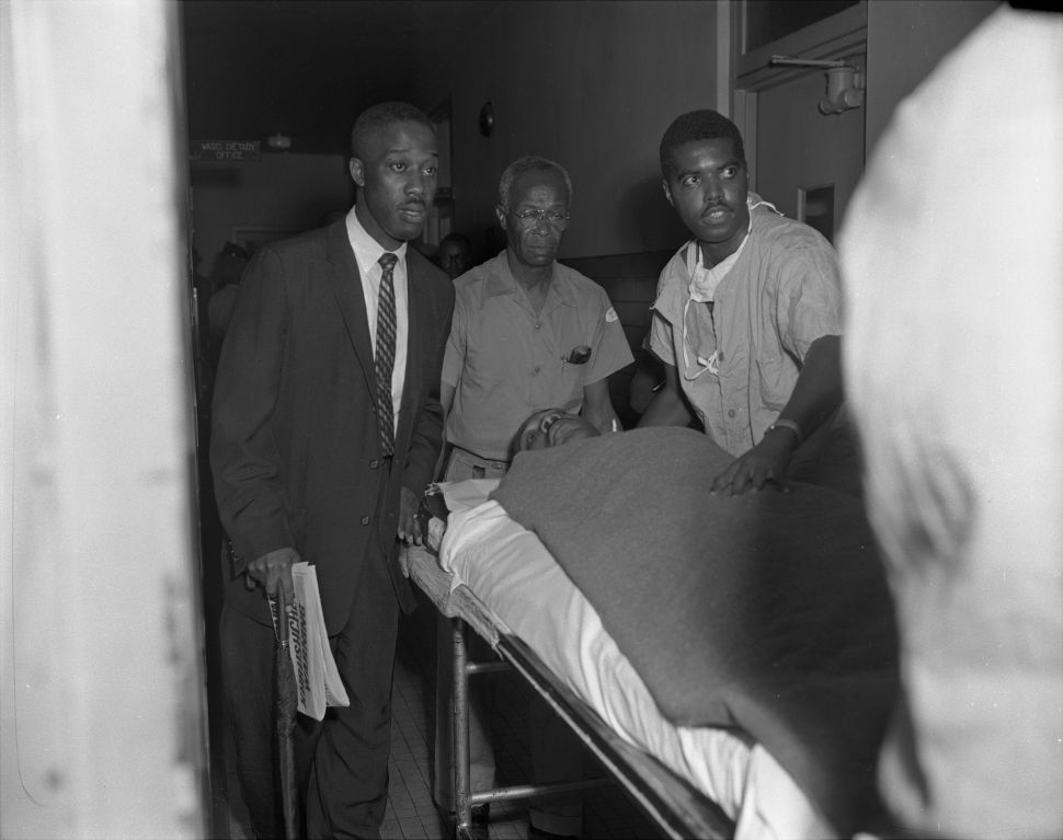 With the letter opener still protruding from his chest, Dr. Martin Luther King is wheeled into Harlem Hospital for treatment after being stabbed.