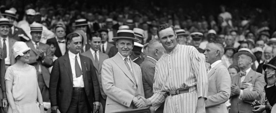 President Calvin Coolidge shakes hands with pitcher Walter Johnson.