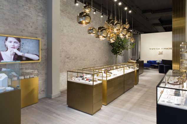 Tom Dixon chandeliers hang above displays in Vinader's shop.