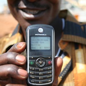 A GiveDirectly recipient showing their cell phone.