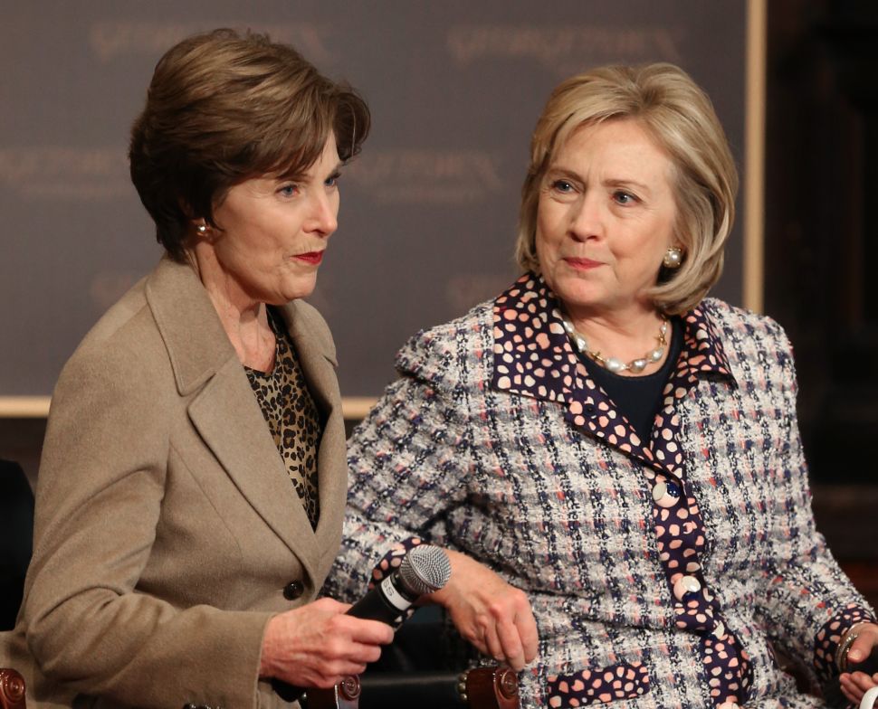 Former Secretary of State Hillary Clinton (R) and former first lady Laura Bush participate in an event to advance the women of Afghanistan in 2013. 