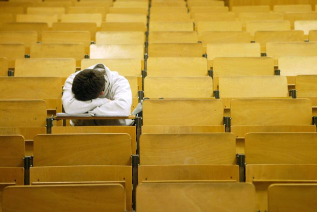 A student naps in a lecture hall.