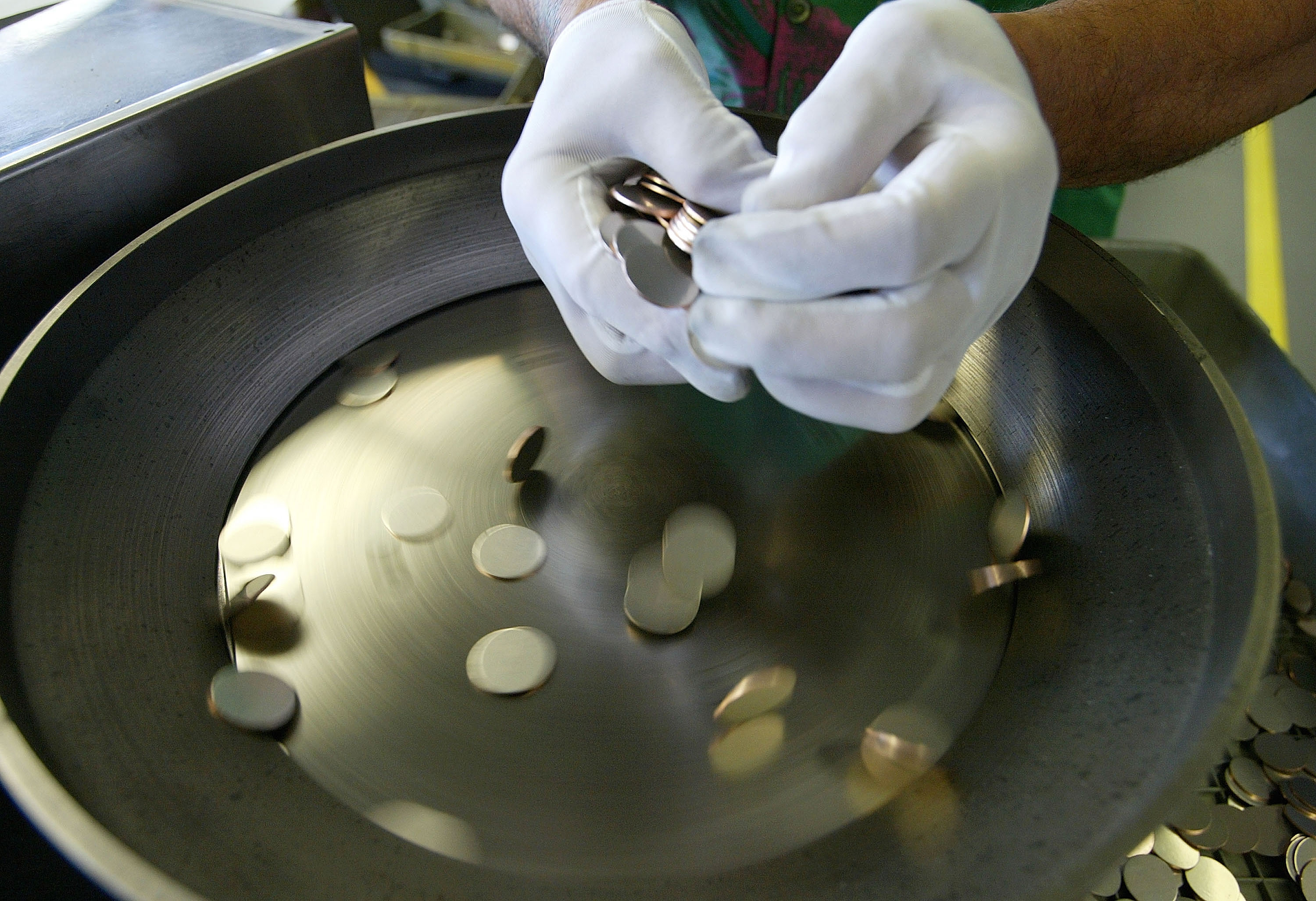 SAN FRANCISCO - MARCH 23: A worker uses a machine to separate coin blanks at the U.S. Mint March 23, 2004 in San Francisco, California. The San Francisco Mint opened in 1937 and is the only mint devoted to producing the only traditional annual sets of highly polished proof coin sets made of both copper-nickel clad and silver.