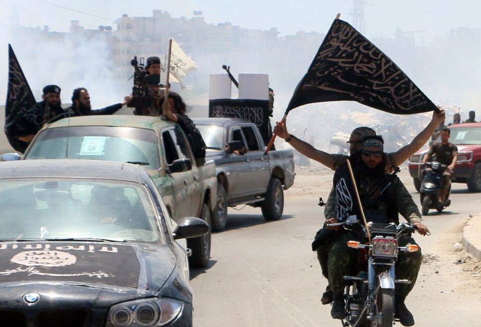 Fighters from Al-Qaeda's Syrian affiliate Al-Nusra Front drive in the northern Syrian city of Aleppo flying Islamist flags as they head to a frontline, on May 26, 2015. Once Syria's economic powerhouse, Aleppo has been divided between government control in the city's west and rebel control in the east since shortly after fighting there began in mid-2012. AFP PHOTO / AMC / FADI AL-HALABI