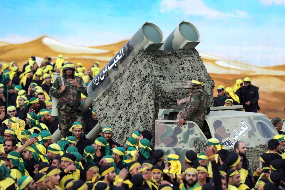 Members of Lebanon's powerful Shiite movement Hezbollah parade with a mock missile launcher .