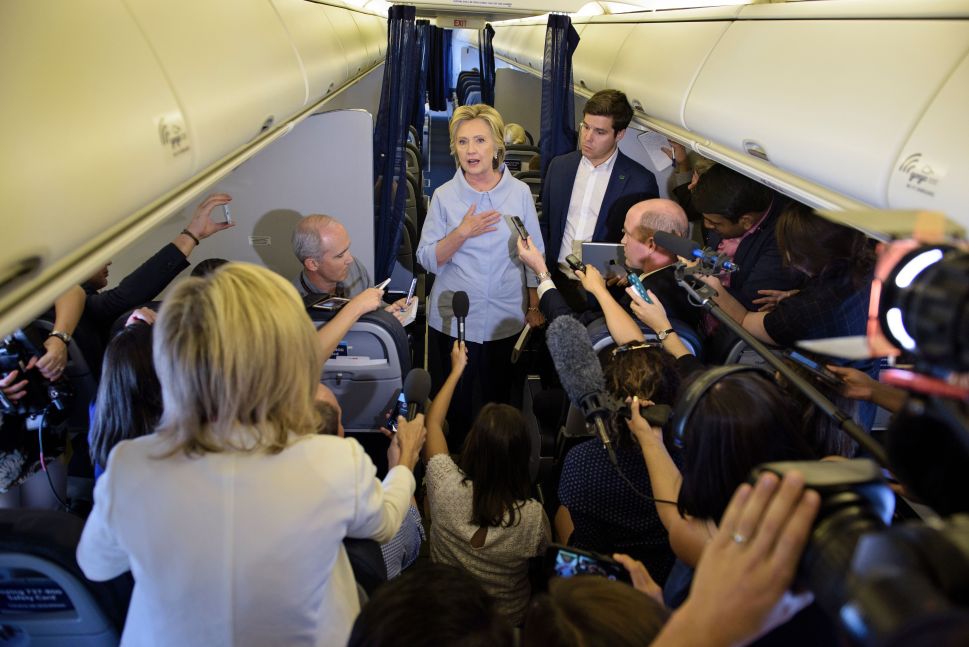 Democratic presidential nominee Hillary Clinton speaks to the press onboard her plane September 5, 2016 above Iowa. 