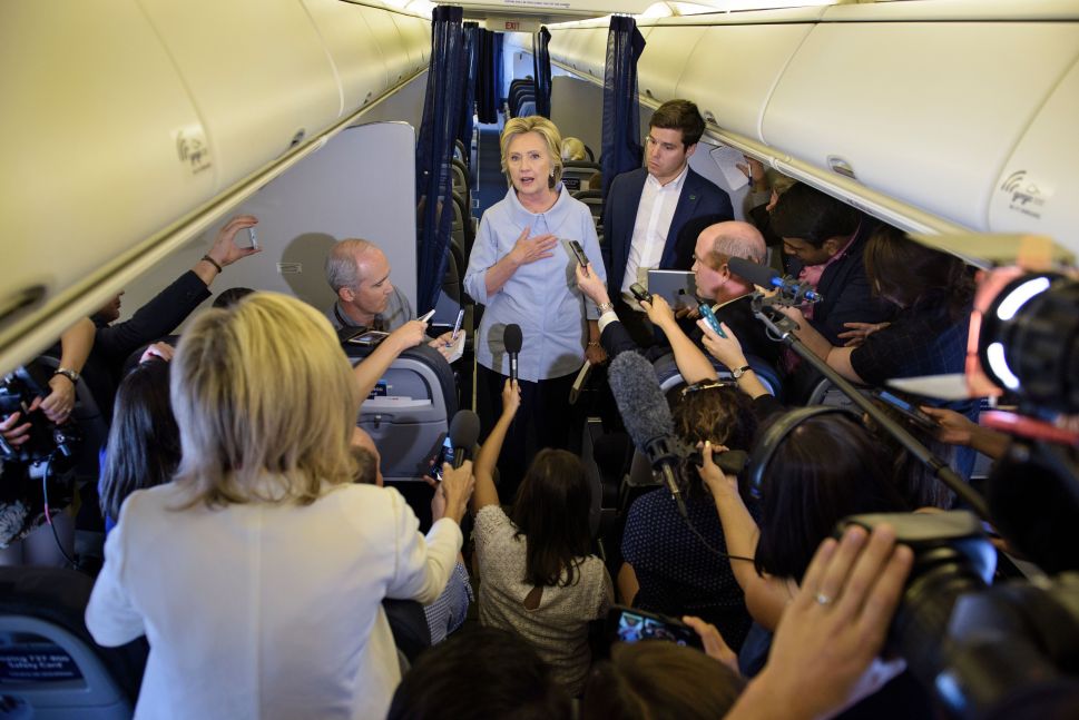 Democratic presidential nominee Hillary Clinton speaks to the press onboard her plane September 5, 2016 above Iowa.