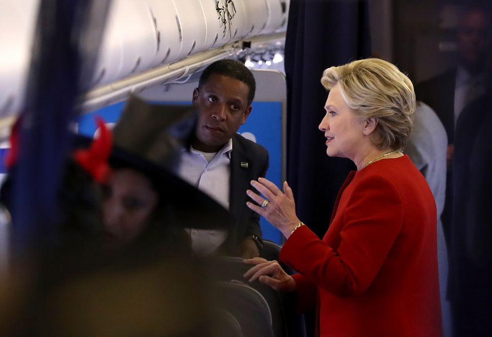 NORTH CANTON, OH - OCTOBER 31: Democratic presidential nominee former Secretary of State Hillary Clinton (R) talks with campaign advisor Darren Peters (L) aboard her campaign plane at Akron-Canton Airport on October 31, 2016 in North Canton, Ohio. With just over a week to go until election day, Hillary Clinton is campaigning in the battleground state of Ohio. 