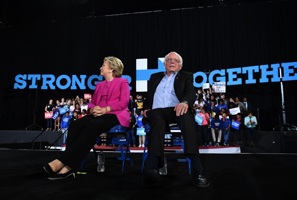 Hillary Clinton and Bernie Sanders listen to singer Pharrell Williams during a campaign rally in Raleigh, North Carolina, on November 3, 2016.