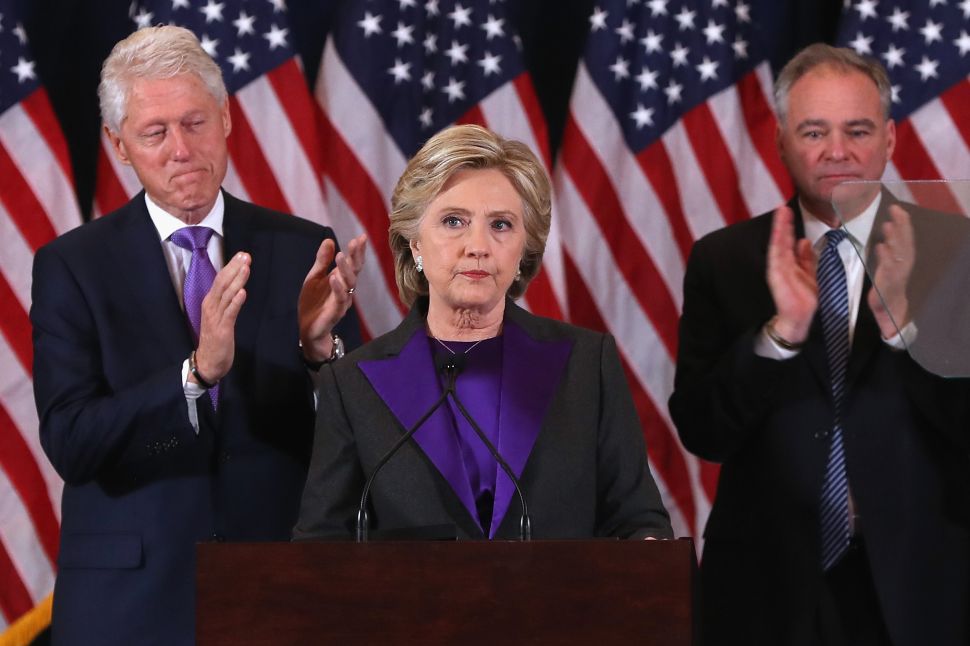 Former Secretary of State Hillary Clinton, accompanied by her husband former President Bill Clinton (L) and running mate Tim Kaine, concedes the presidential election at the New Yorker Hotel on November 9, 2016 in New York City.
