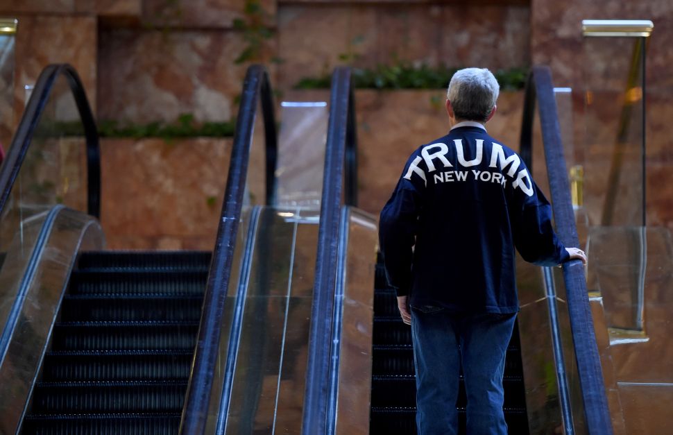 A Trump supporter takes the escalator to the 2nd level at Trump Tower as President-elect Donald Trump holds meetings in his office at Trump Tower on 5th Avenue November 11, 2016. / AFP / TIMOTHY A. CLARY