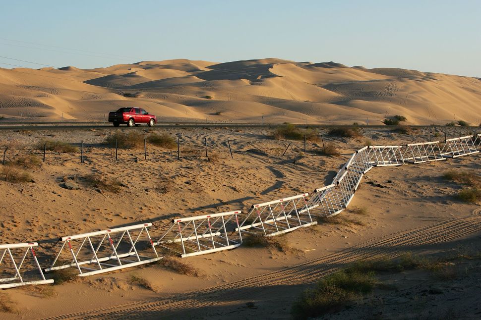 A vehicle-proof barrier lines the south side of Interstate 8 at the Imperial Dunes, a short distance north of the US-Mexico border where no fence divides the two nations, October 8, 2006.