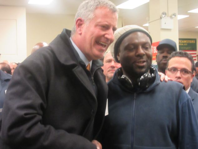 Mayor Bill de Blasio poses with a worker after his speech.