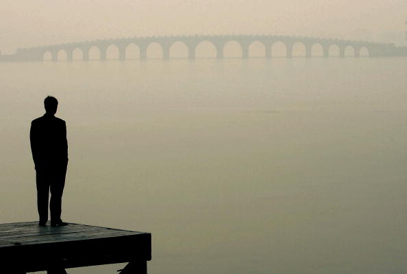 A man looks towards a bridge in heavy fog on December 14, 2004 in Beijing, China. 