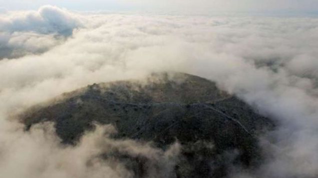 The city’s acropolis is barely visible during a cloudy day on the Thessalian plains.