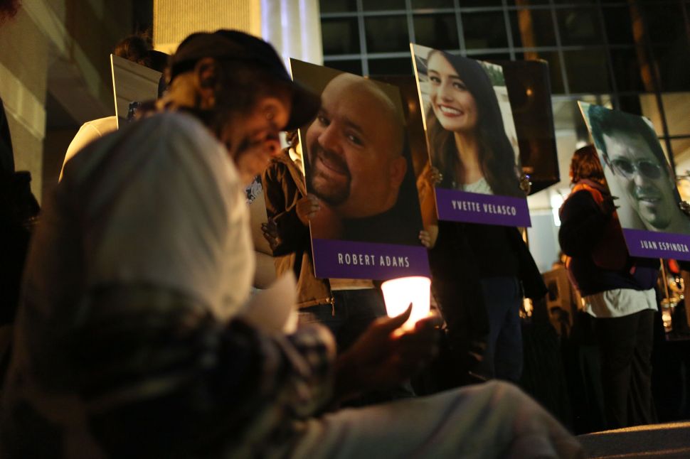 SAN BERNARDINO, CA - DECEMBER 07: Photographs of victims of the terrorist attack on the Inland Regional Center are seen as people hold candles while attending a vigil held at the San Bernardino County Board of Supervisors headquarters to remember those injured and killed during the shooting on December 7, 2015 in San Bernardino, California. FBI and other law enforcement officials continue to investigate the mass shooting that left 14 people dead and another 21 injured on December 2.