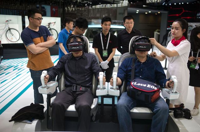 People test a virtual drive of the Kia Autonomous Vehicle at the Beijing Auto Show in Beijing on April 25, 2016. Global carmakers gathered in Beijing on April 25 to show off their wares as competition intensifies and growth slows in the world's biggest auto market, with the key SUV and new energy vehicle sectors the focus of attention. / AFP / FRED DUFOUR (Photo credit should read FRED DUFOUR/AFP/Getty Images)