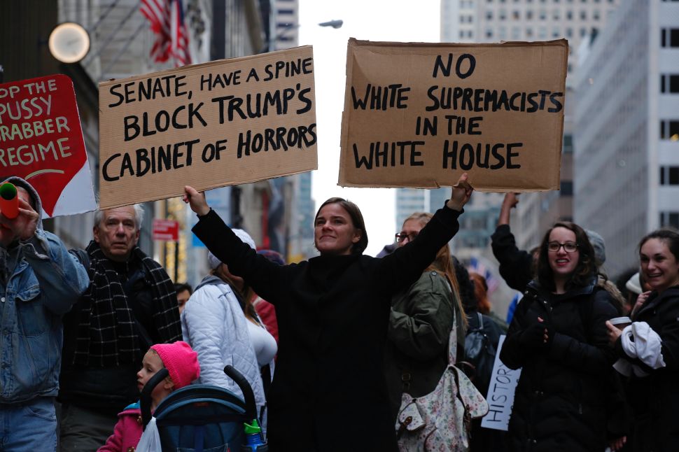 A woman protests against US President-elect Donald Trump in front of Trump Tower on November 20, 2016 in New York. / AFP / KENA BETANCUR 