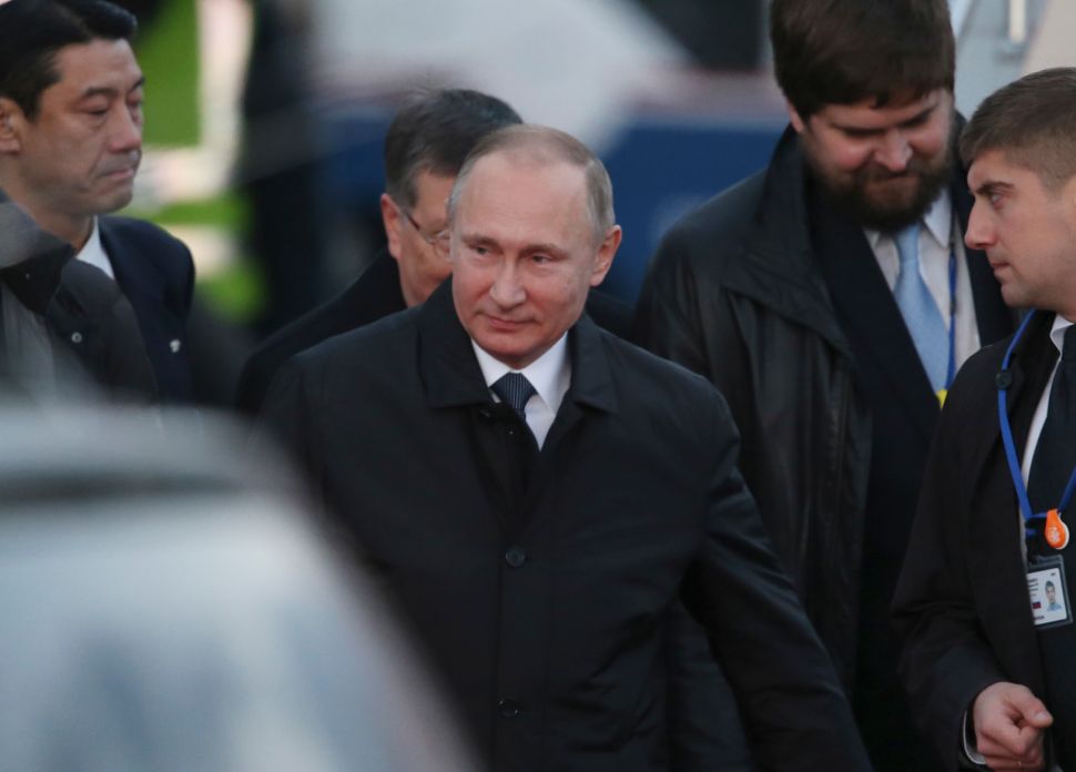 Russian President Vladimir Putin (C) arrives at Yamaguchi Ube Airport in Ube, western Japan on December 15, 2016. Putin arrived in Japan on December 15 for a hot spring summit aimed at reaching a deal over a group of small islands that have prevented the countries from formally ending their World War II hostilities. / AFP / POOL /