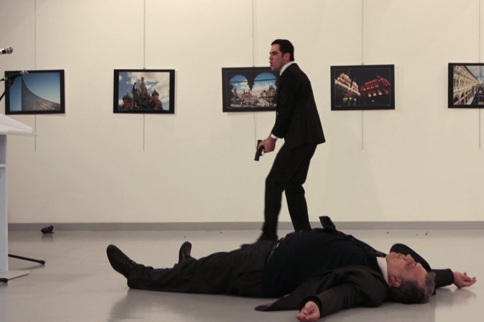 his picture taken on December 19, 2016 shows Andrey Karlov (R), the Russian ambassador to Ankara, lying on the floor after being shot to death by a gunman.