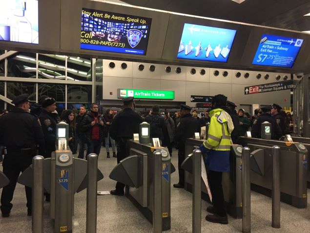 Police officers at Howard Beach tell protestors that only airline passengers and employees can take the AirTrain.