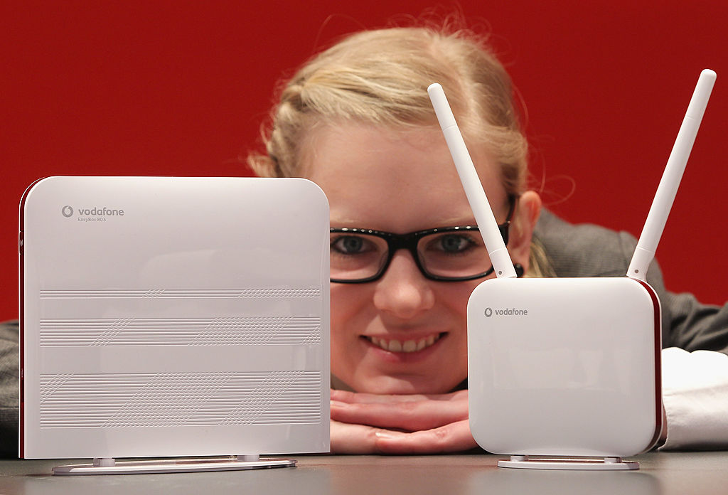 HANOVER, GERMANY - FEBRUARY 28: A hostess presents the new Vodafone LTE high-speed router (L) and modem at the Vodafone stand at the CeBIT technology trade fair on February 28, 2011 in Hanover, Germany. LTE is a new mobile broadband standard that promises speeds many times that of current UMTS and HSDPA systems and is being introduced foremost in rural areas in Germany that have thus far been cut off from broadband Internet connectivity. CeBIT 2011 will be open to the public from March 1-5. (Photo by Sean Gallup/Getty Images)