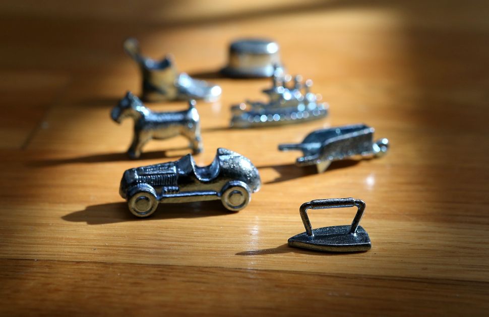 FAIRFAX, CA - FEBRUARY 06: In this photo illustration, Monopoly board game pieces are displayed on February 6, 2013 in Fairfax, California. Toy maker Hasbro, Inc. announced today that fans of the board game Monopoly voted in an online contest to eliminate the iron playing figure and replace it with a cat figure. The cat gamepiece received 31 percent of the online votes to beat out four other contenders, a robot, diamond ring, helicopter and guitar.