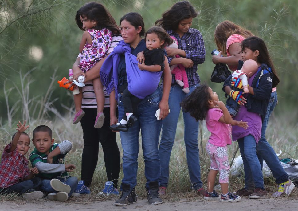 MISSION, TX - JULY 24: Central American immigrants await transportation to a U.S. Border Patrol processing center after crossing the Rio Grande from Mexico into the Texas on July 24, 2014 near Mission, Texas. Tens of thousands of undocumented immigrants, many of them families or unaccompanied minors, have crossed illegally into the United States this year and presented themselves to federal agents, causing a humanitarian crisis on the U.S.-Mexico border. The Rio Grande Sector of the border has the heaviest traffic of illegal crossings of the entire U.S.-Mexico border. (Photo by