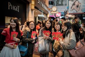 A promotional model poses with pedestrians to whom she distributed bitcoin coupons to mark the Chinese New Year in Hong Kong on January 30, 2014. Bitcoin, invented in the wake of the global financial crisis by a mysterious computer guru using the pseudonym Satoshi Nakamoto, is a form of cryptography-based e-money. AFP PHOTO / Philippe Lopez (Photo credit should read PHILIPPE LOPEZ/AFP/Getty Images)