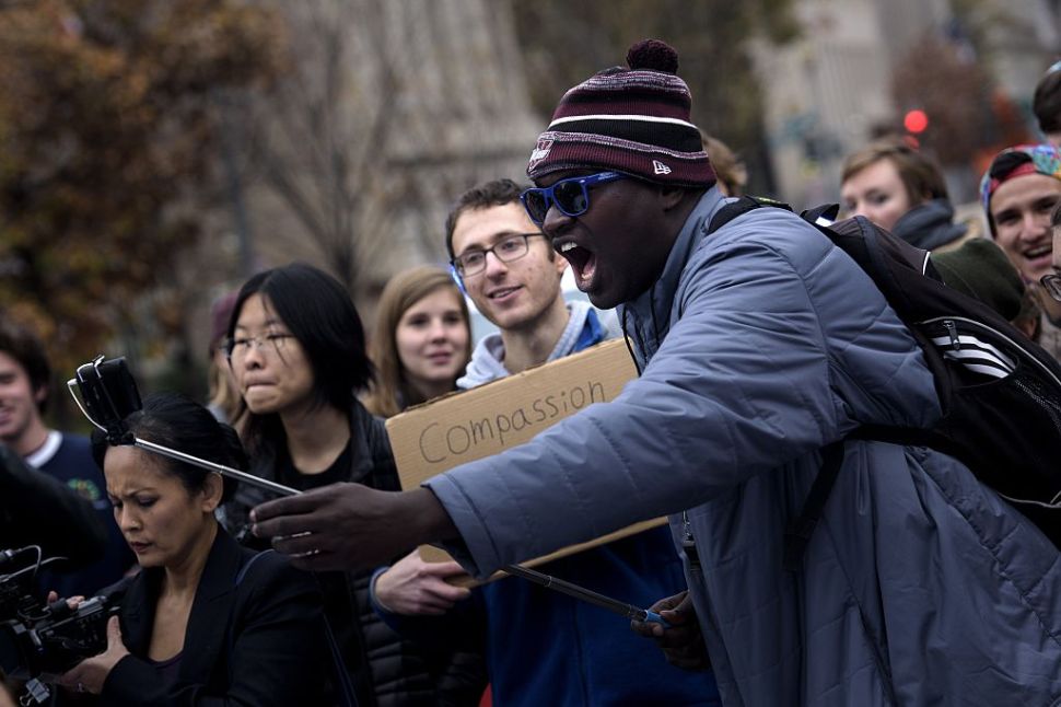 A man uses a selfie stick on his smartphone during a protest on H Street near the White House November 9, 2015 in Washington, DC. Activists gathered to protest the mining of fossil fuels, police violence and racism, and immigration issues. AFP PHOTO/BRENDAN SMIALOWSKI (Photo credit should read BRENDAN SMIALOWSKI/AFP/Getty Images)