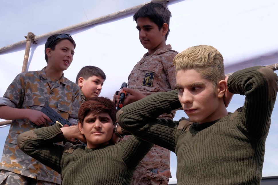 Iranian schoolboys reenact the detention of US sailors by Iran's Revolutionary Guards during celebrations marking the 37th anniversary of the Islamic revolution on February 11, 2016 in Tehran.