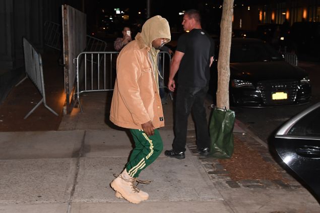 Kanye hides out in a hoodie.